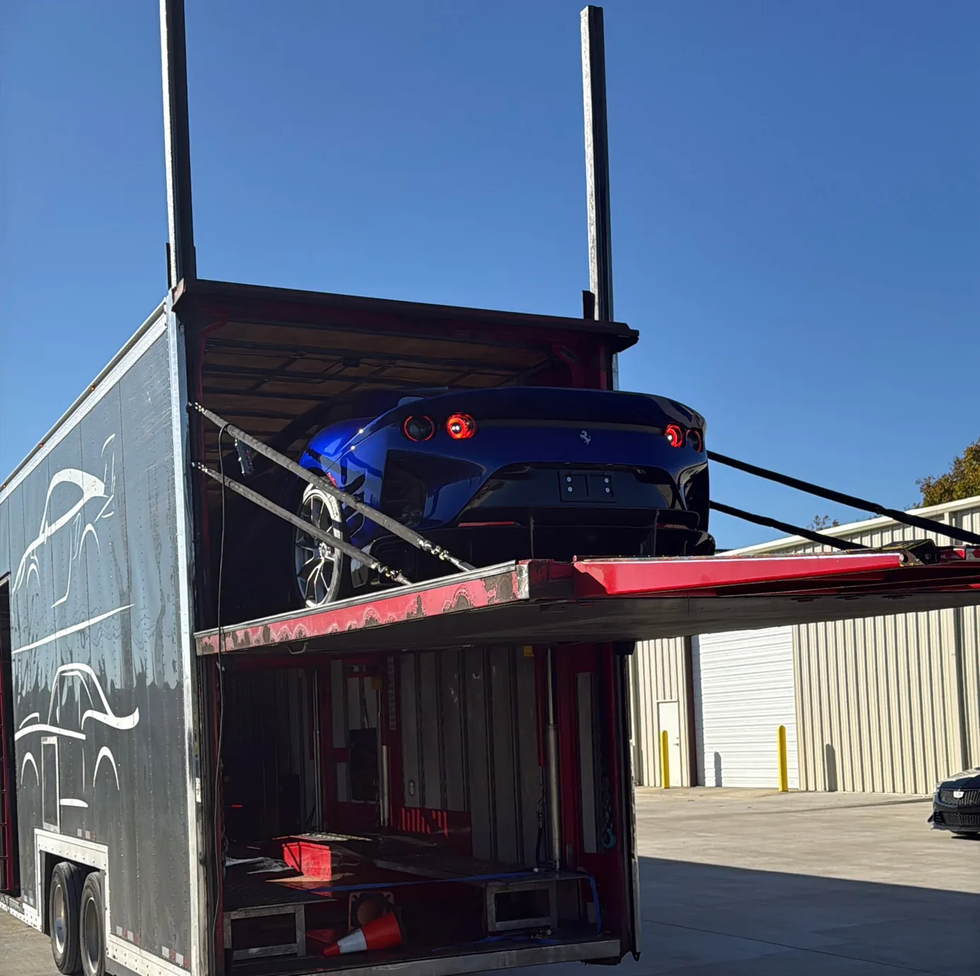 The 812 Competizione on the transporter's top deck, seen from below and behind