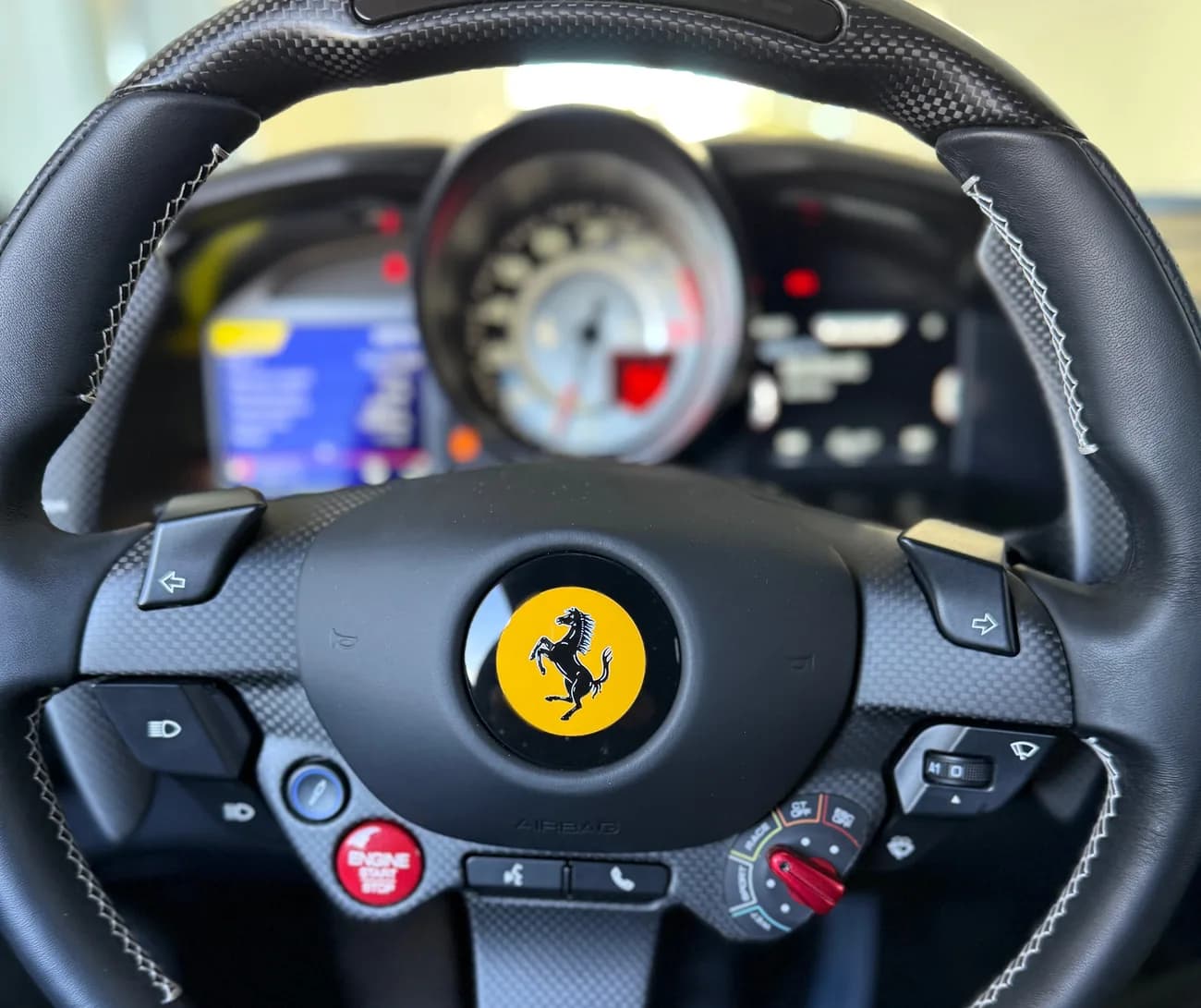 The carbon fibre steering wheel, instrument cluster visible behind it