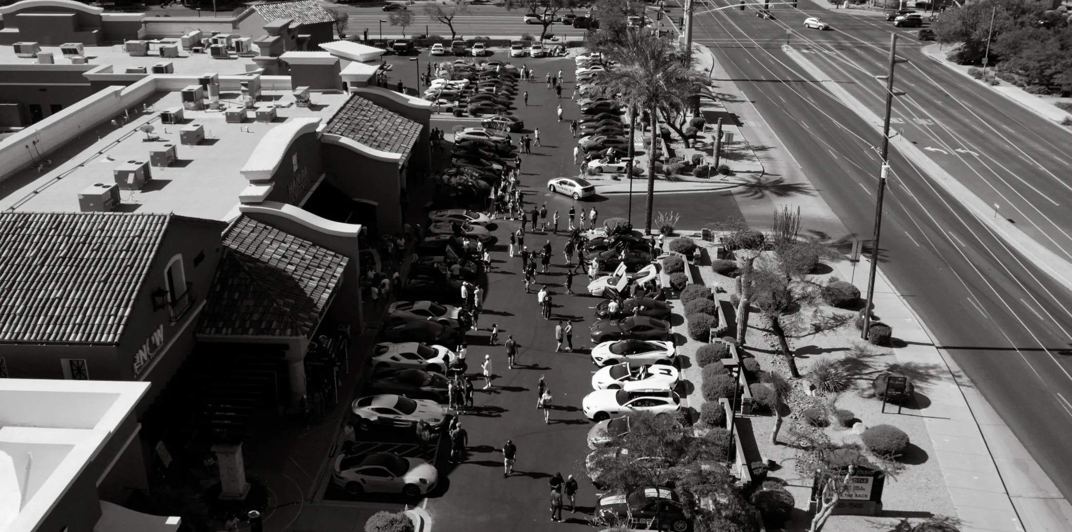 Looking down on the event: cars parked along both sides of the street and people walking between them